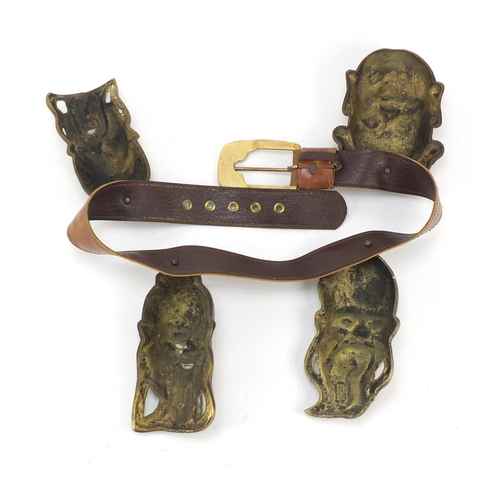 3780 - Leather belt housing four Chinese brass Emperor/Buddha heads, the largest head 16cm high