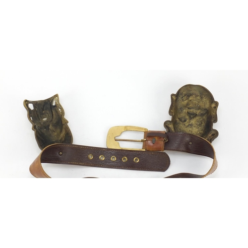 3780 - Leather belt housing four Chinese brass Emperor/Buddha heads, the largest head 16cm high