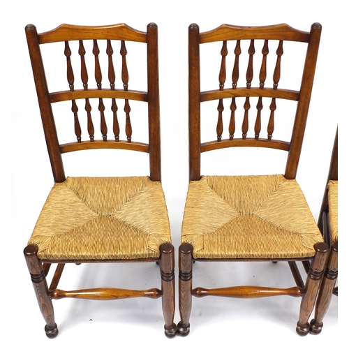 1472 - Circular oak dining table and eight Lancashire spindle back chairs with rush seats, the table 75cm H... 