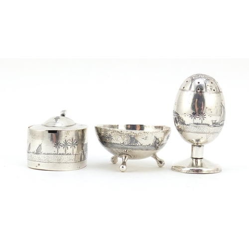 3085 - Egyptian silver niello work three piece cruet depicting temples and sailing boats, the largest 7cm h... 