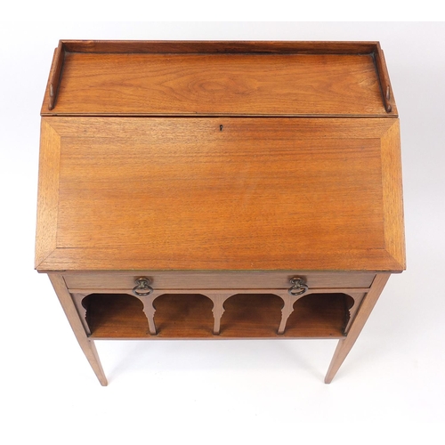 1486 - Liberty & Co, Arts & Crafts walnut student's bureau with a fall above a drawer and open shelf, 83cm ... 