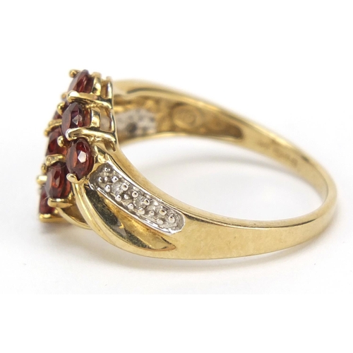 2354 - 9ct gold red stone crossover ring with diamond shoulders, size O, 2.9g