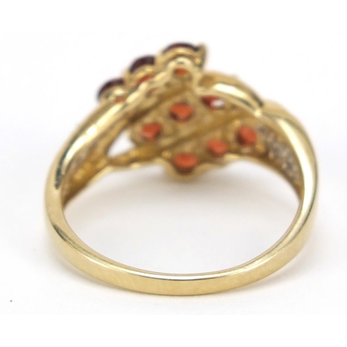 2354 - 9ct gold red stone crossover ring with diamond shoulders, size O, 2.9g