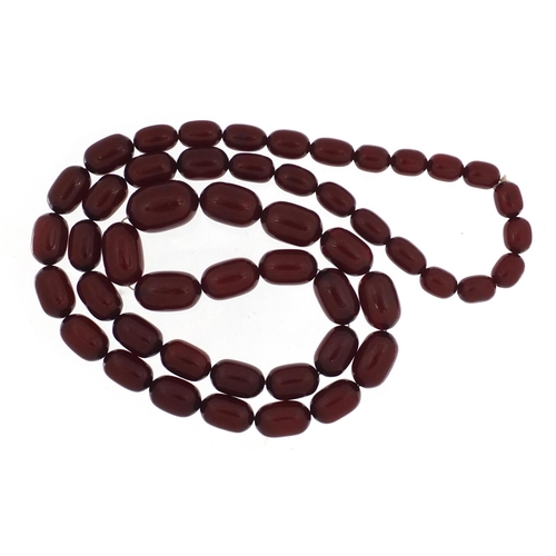 2410 - Cherry amber coloured bead necklace, 92cm in length, the largest bead 2.7cm in length, 115.0g