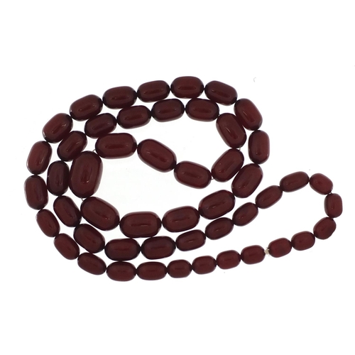 2410 - Cherry amber coloured bead necklace, 92cm in length, the largest bead 2.7cm in length, 115.0g