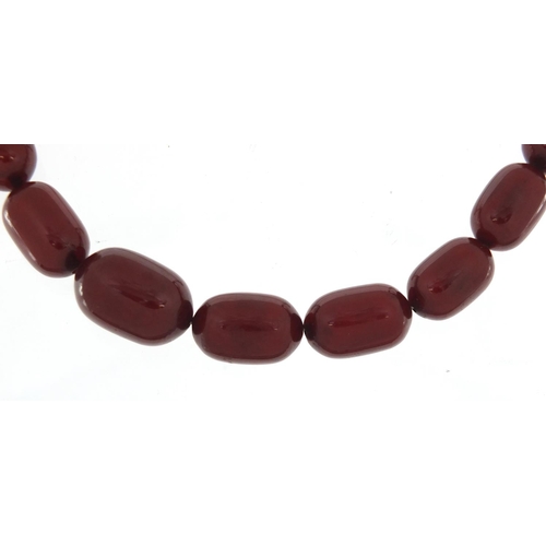 2410 - Cherry amber coloured bead necklace, 92cm in length, the largest bead 2.7cm in length, 115.0g