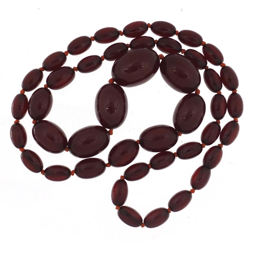 2389 - Cherry amber coloured bead necklace, 80cm in length, the largest bead 2.9cm in length, 81.0g