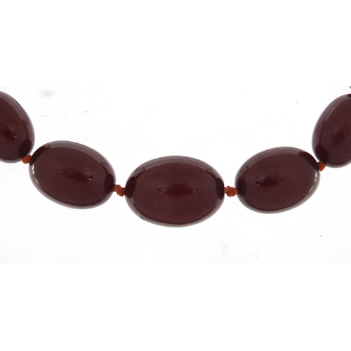 2389 - Cherry amber coloured bead necklace, 80cm in length, the largest bead 2.9cm in length, 81.0g