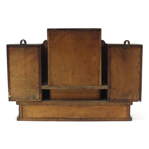 1510 - Art Deco oak wall hanging unit with bevelled peach glass mirror, having three cupboard doors above t... 