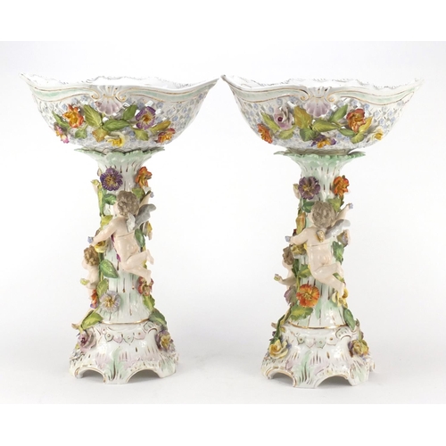 99 - Dresden, large pair of floral encrusted porcelain centrepieces with pierced baskets on naturalistic ... 