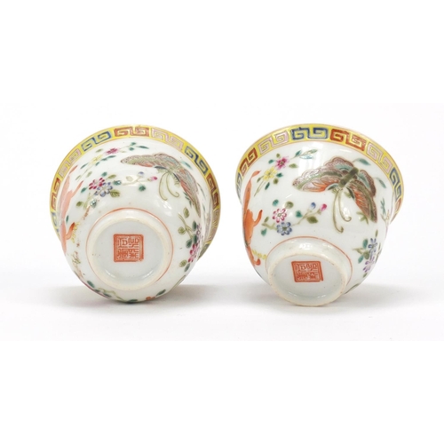 115 - Pair of Chinese porcelain tea cups, each finely hand painted in the famille rose palette with butter... 