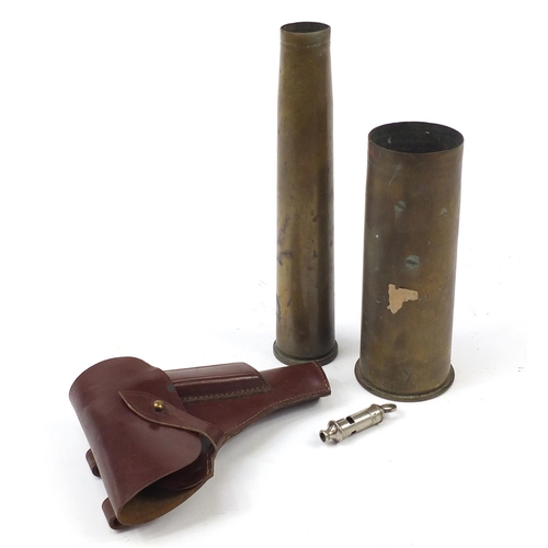 2047 - Militaria including a German gun holster and two trench shells, the largest 31cm high