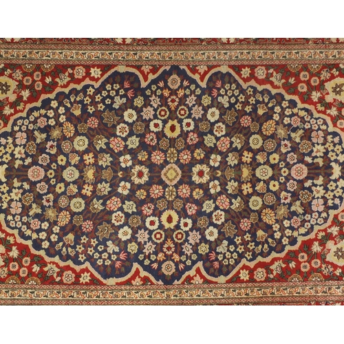 1528A - Rectangular Persian Hereke design rug decorated with stylised flowers onto midnight blue and red gro... 