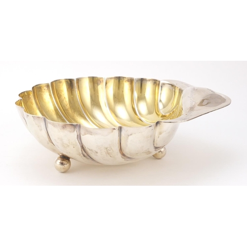 3051 - Atkin Brothers, Edward VII large silver shell shaped bowl with gilt interior, raised on three ball f... 