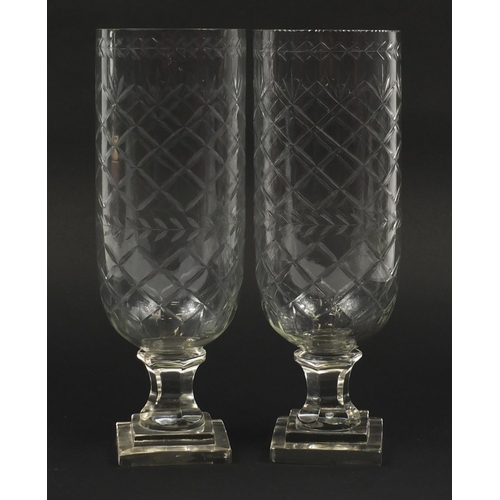 102 - Pair of Georgian design cut glass celery vases raised on stepped square bases, each 34cm high