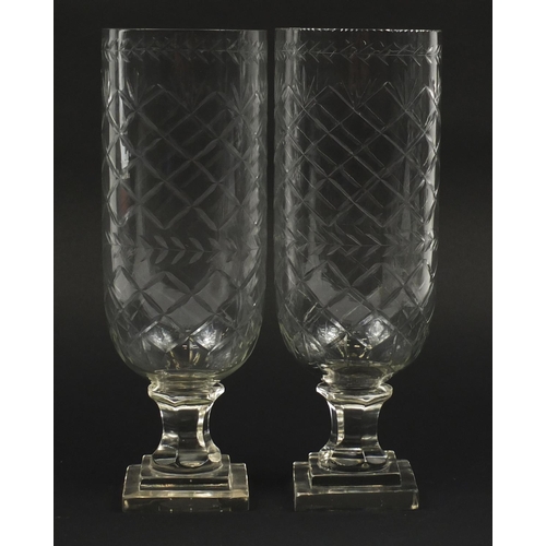 102 - Pair of Georgian design cut glass celery vases raised on stepped square bases, each 34cm high