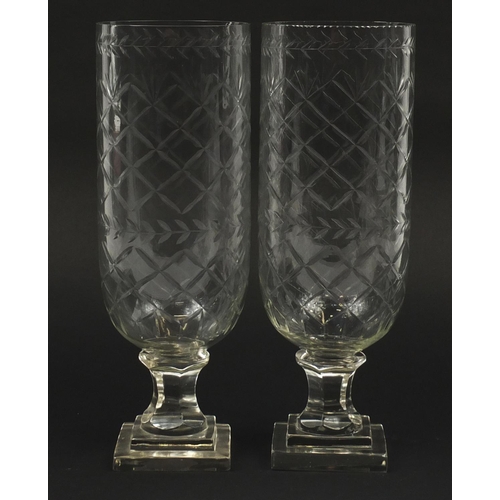 102 - Pair of Georgian design cut glass celery vases raised on stepped square bases, each 34cm high