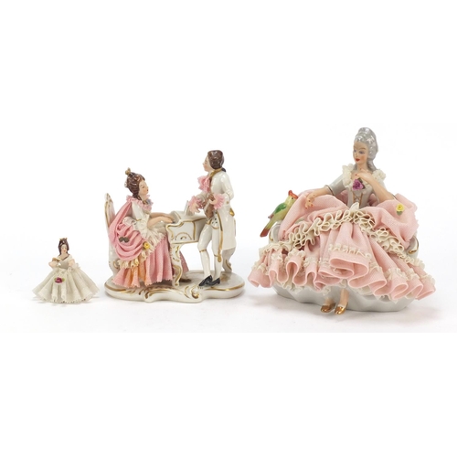 483 - Dresden, three German porcelain lace figurines including a group of two lovers, the largest 18cm wid... 