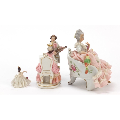 483 - Dresden, three German porcelain lace figurines including a group of two lovers, the largest 18cm wid... 