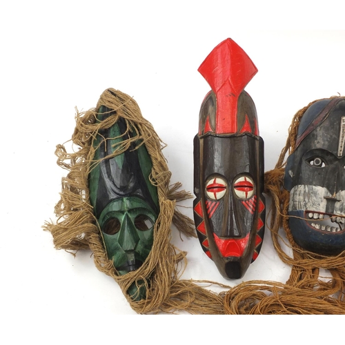 3772 - Six hand painted African carved wood face masks, the largest 46cm high