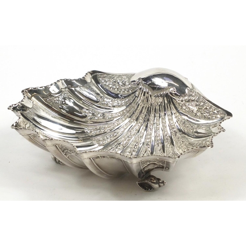 3031 - Atkin Brothers, large Victorian silver shell shaped bowl embossed with flowers and raised on three s... 