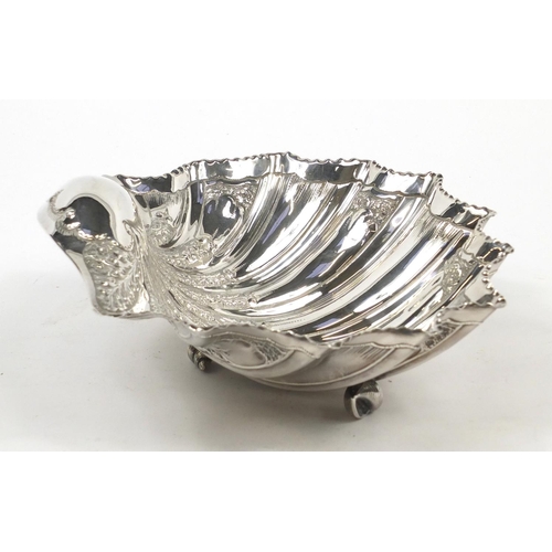 3031 - Atkin Brothers, large Victorian silver shell shaped bowl embossed with flowers and raised on three s... 