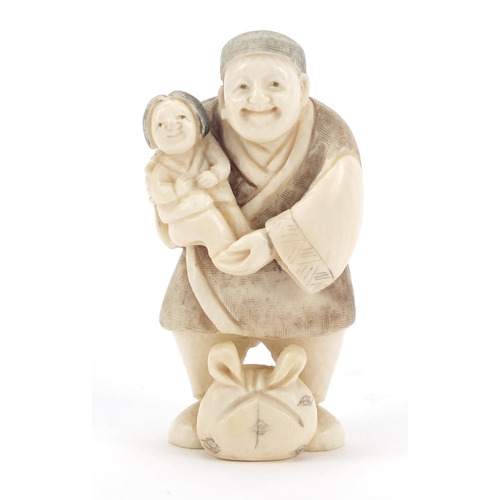 473 - Japanese carved ivory netsuke of a man holding a child, character marks to the base, 6.5cm high