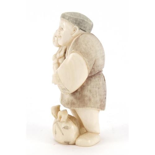 473 - Japanese carved ivory netsuke of a man holding a child, character marks to the base, 6.5cm high