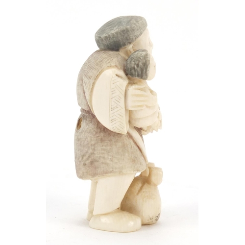 473 - Japanese carved ivory netsuke of a man holding a child, character marks to the base, 6.5cm high