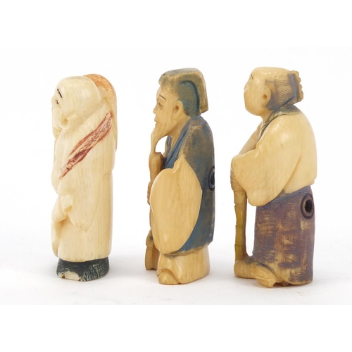 474 - Three Japanese part stained carved ivory netsukes of elders, character marks to the bases, the large... 