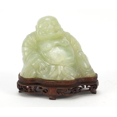 470 - Chinese carved green jade Buddha raised on carved hardwood stand, 11.5cm wide