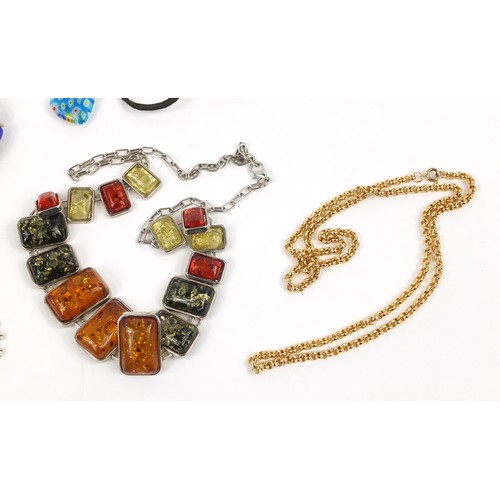 2937 - Costume jewellery including a natural amber necklace, Swatch watch and charms