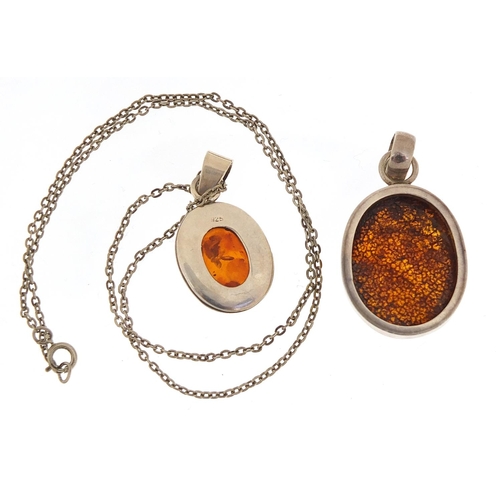 2216 - Two silver and amber pendants, one with silver necklace, the largest pendant 4.5cm high, total 19.5g