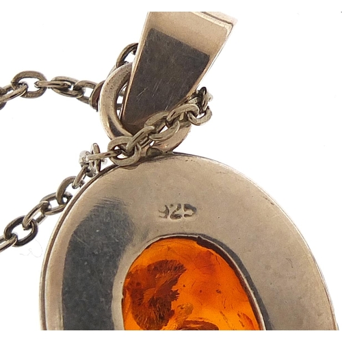 2216 - Two silver and amber pendants, one with silver necklace, the largest pendant 4.5cm high, total 19.5g