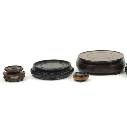167 - Seven Chinese carved hardwood stands including two pairs, the largest 16cm in diameter