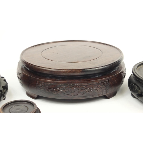 167 - Seven Chinese carved hardwood stands including two pairs, the largest 16cm in diameter
