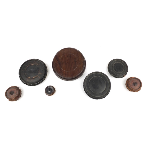 167 - Seven Chinese carved hardwood stands including two pairs, the largest 16cm in diameter