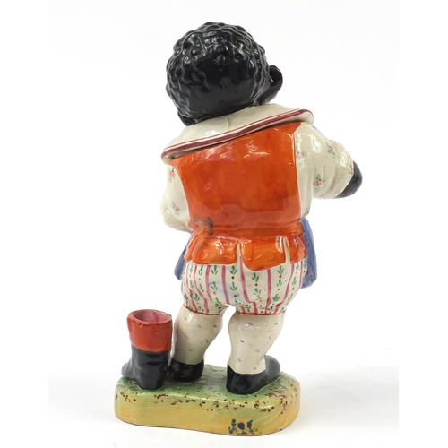 18 - Victorian Staffordshire tobacco jar and cover in the form of a standing black boy wearing an apron s... 