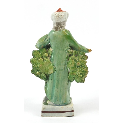 143 - 18th century Pearlware figure in Turkish costume wearing a turban, 15.5cm high