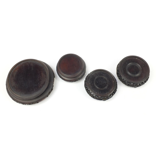 166 - Four Chinese carved hardwood stands, the largest 16cm in diameter