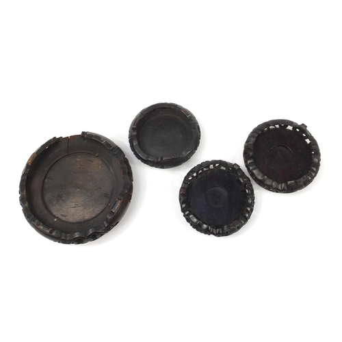 166 - Four Chinese carved hardwood stands, the largest 16cm in diameter