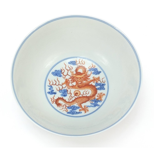 335 - Chinese blue and white with iron red porcelain bowl, finely hand painted with two dragons amongst cl... 