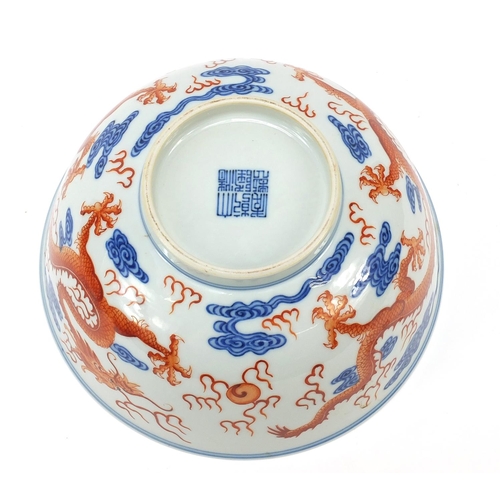 335 - Chinese blue and white with iron red porcelain bowl, finely hand painted with two dragons amongst cl... 