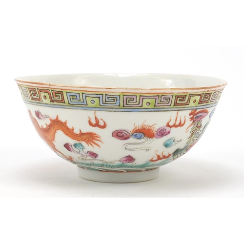 96 - Chinese porcelain bowl hand painted in the famille rose palette with a phoenix and dragon above wave... 