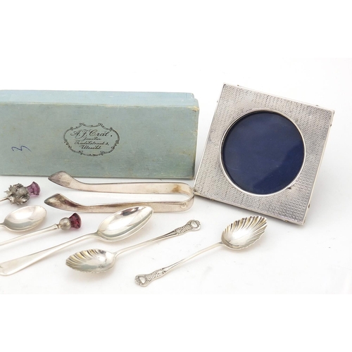 840 - Silver items including an Edwardian silver easel photo frame, pair of German sugar tongs and teaspoo... 