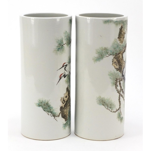 660 - Pair of Chinese porcelain cylindrical vases hand painted with cranes amongst pine trees, 28.5cm high