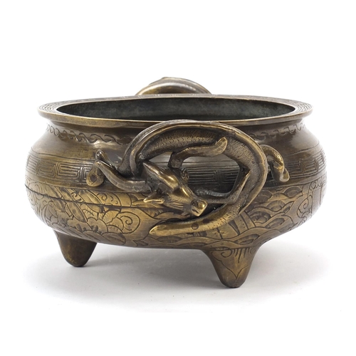 104 - Chinese patinated bronze tripod censer with twin dragon handles, four figure character marks to the ... 