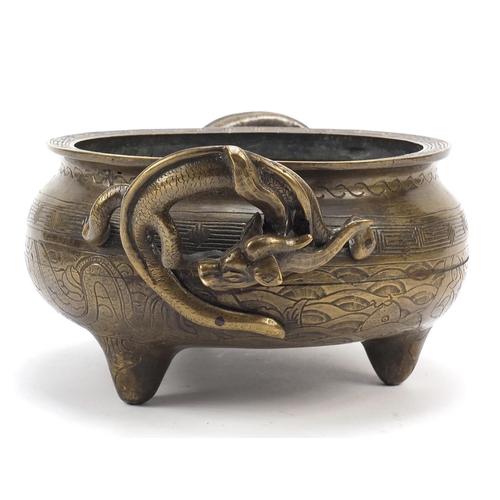 104 - Chinese patinated bronze tripod censer with twin dragon handles, four figure character marks to the ... 