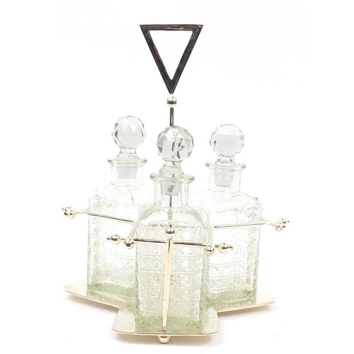 136 - Modernist silver plated three bottle tantalus with glass decanters in the style of Christopher Dress... 