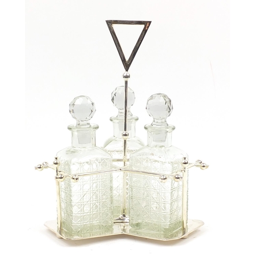 136 - Modernist silver plated three bottle tantalus with glass decanters in the style of Christopher Dress... 